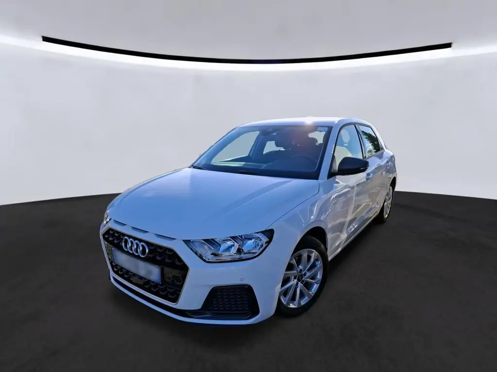 Audi A1 blanche vue en 3/4 avant droit, avec calandre noire et jantes alu 17 pouces dans un garage.