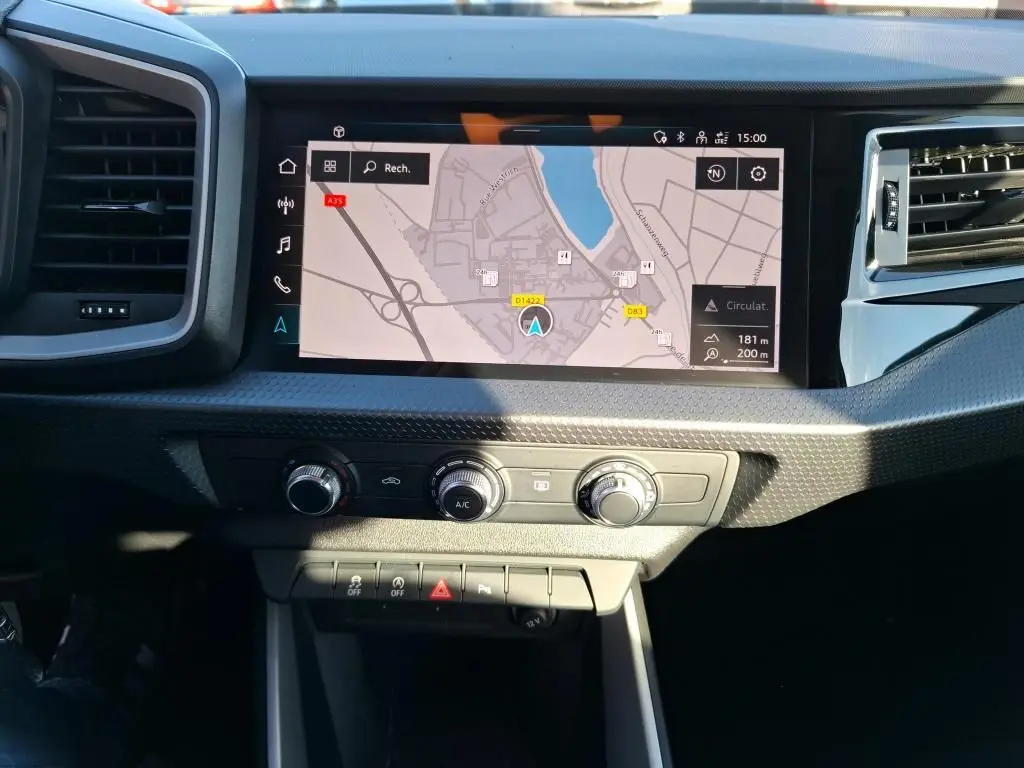 Gros plan sur la commande des vitres électriques et rétroviseurs sur la porte côté conducteur d'une Audi A1 blanche.