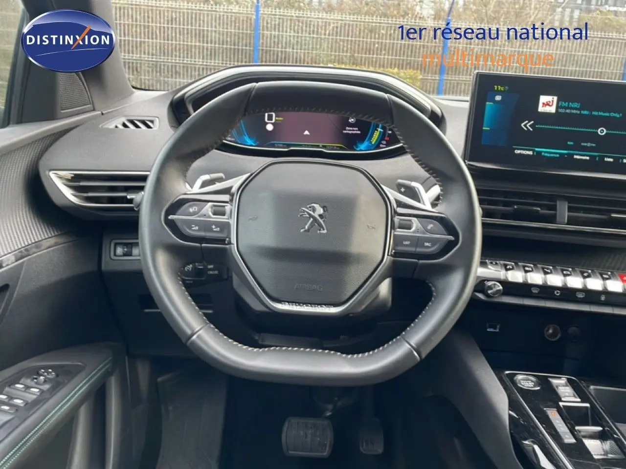 Vue intérieure centrée sur le volant noir du Peugeot 3008 2024 avec tableau de bord digital et écran tactile.