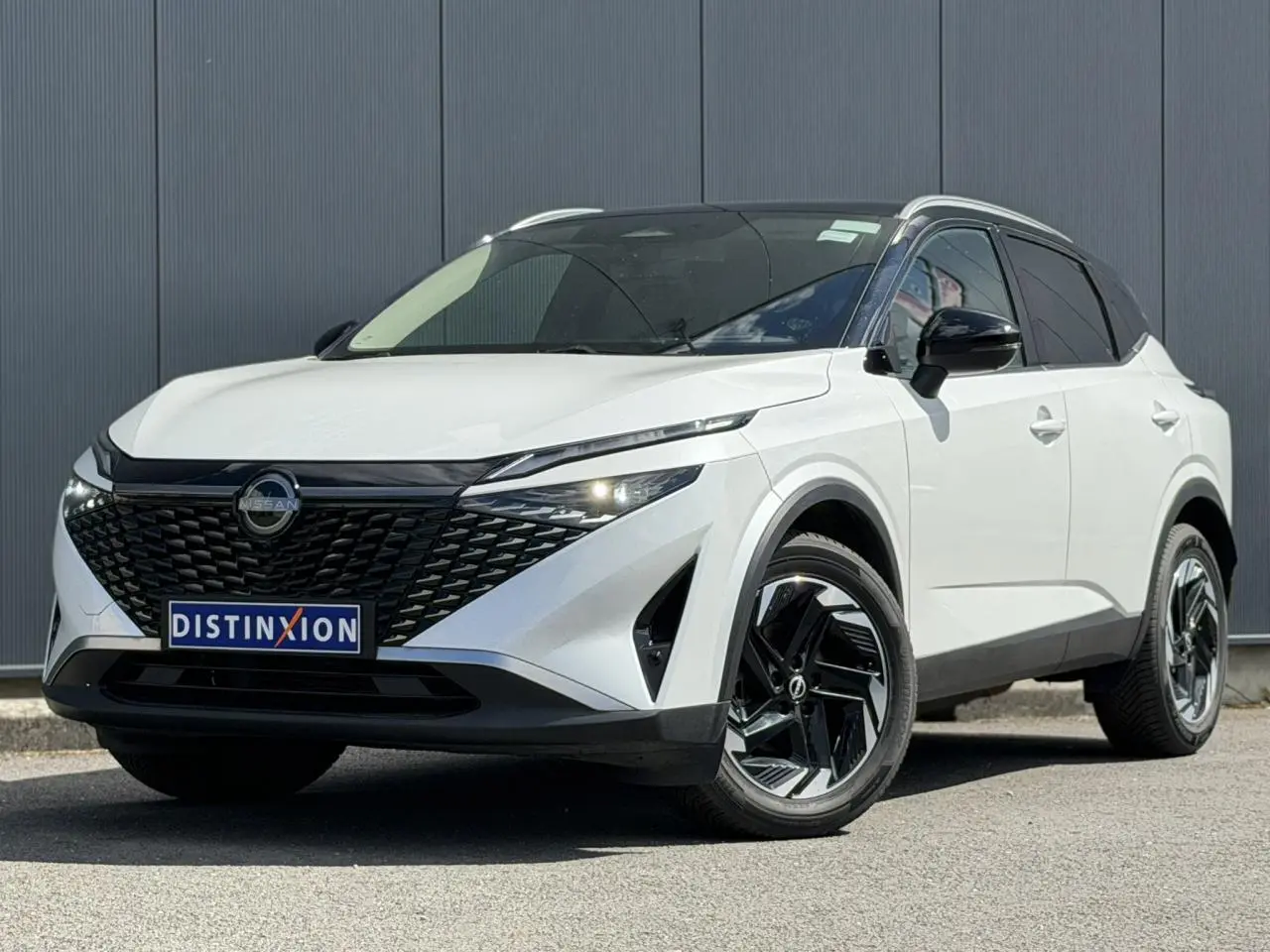 Nissan Qashqai 2025 blanc nacré et noir, vue 3/4 avant avec calandre noire et jantes alliage noires.