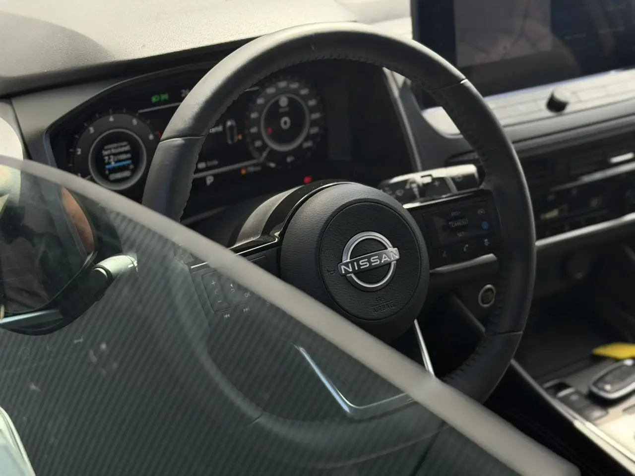 Vue rapprochée du volant noir et du tableau de bord numérique du Nissan Qashqai 2025, intérieur moderne et épuré.