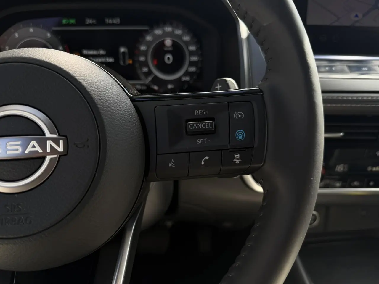 Gros plan sur le volant cuir noir du Nissan Qashqai 2025 avec commandes de régulateur et assistance au pilotage.