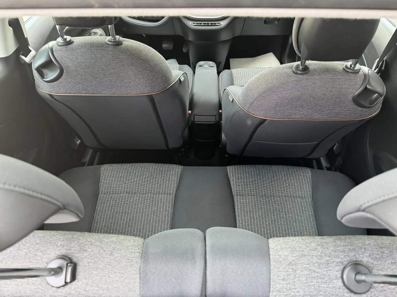 Vue arrière intérieure sur la banquette et les dossiers gris anthracite à rayures de la Fiat 500 électrique blanche 2022.
