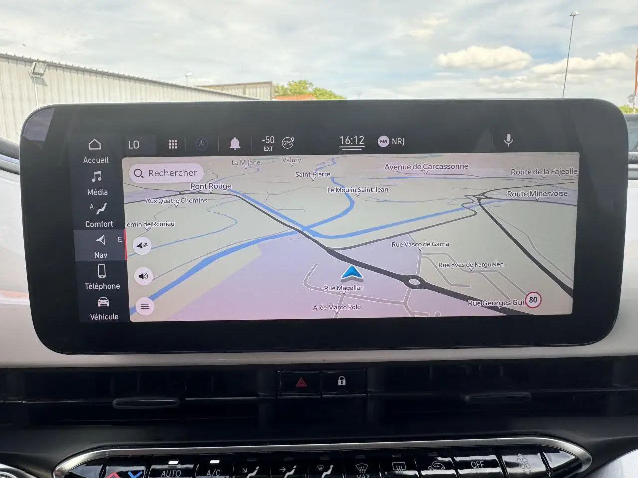 Écran tactile du système de navigation Uconnect 10,25" dans le tableau de bord d'une Fiat 500 électrique blanche.