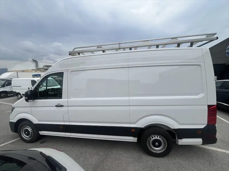 Vue latérale côté droit d'un Volkswagen Crafter fourgon blanc L3H3 avec galerie de toit en aluminium.