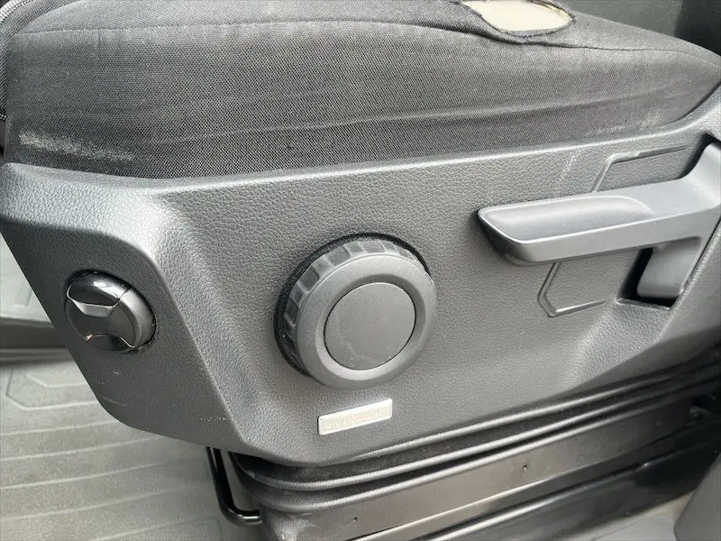 Détail de la commande de réglage du siège côté gauche dans un Volkswagen Crafter Fourgon blanc 2019.