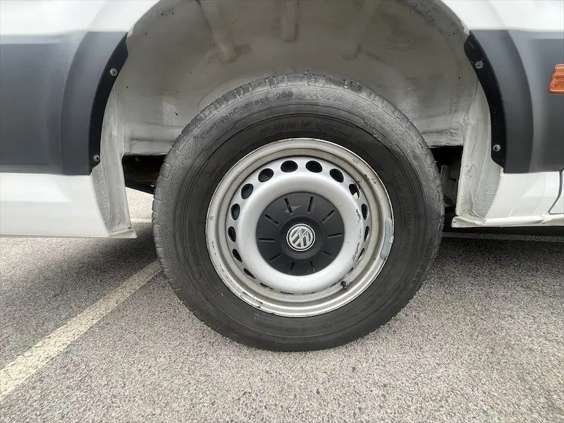 Gros plan sur la roue avant droite blanche d'un Volkswagen Crafter Fourgon L3H3 Business Line 2019 avec logo VW central.