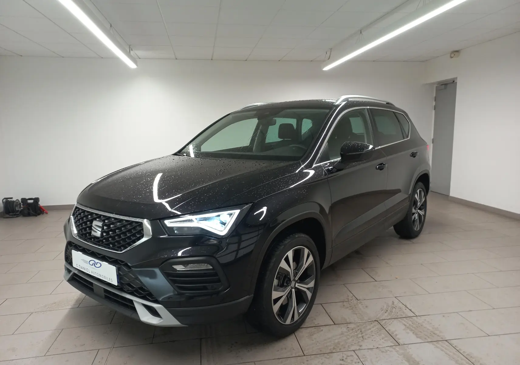 SEAT Ateca 2.0 TDI 150 DSG7 COPA noir Magic Nacré, vue 3/4 avant avec jantes alliage 18'' usinées dans un showroom.