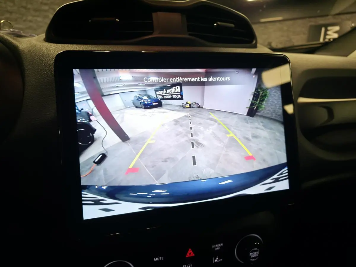 Écran tactile intérieur montrant la caméra de recul du Jeep Renegade gris avec repères de stationnement en garage.