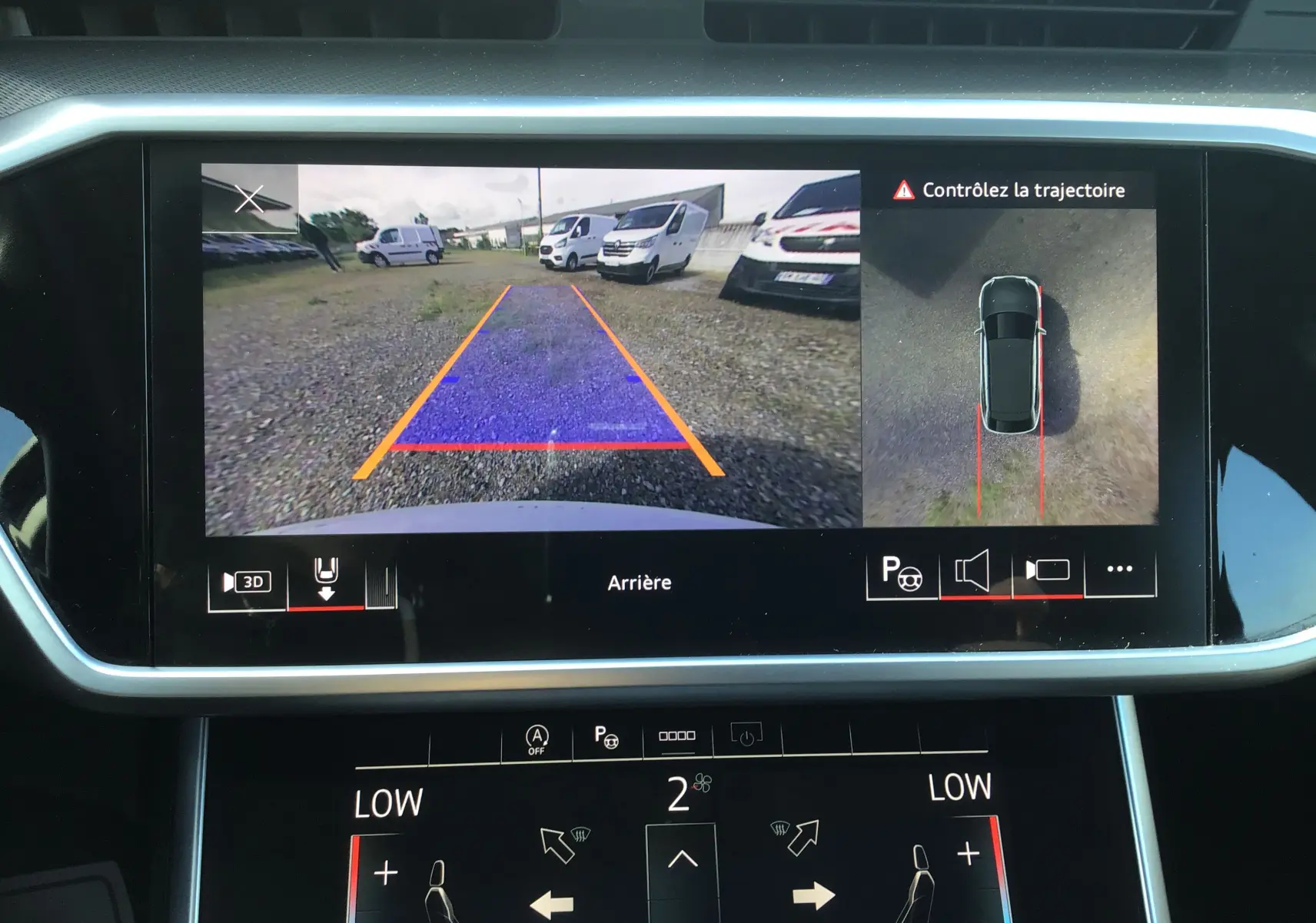 Écran central de l’Audi A6 Avant blanc glacier 2022 montrant la caméra de recul et l’aide au stationnement en vue arrière.