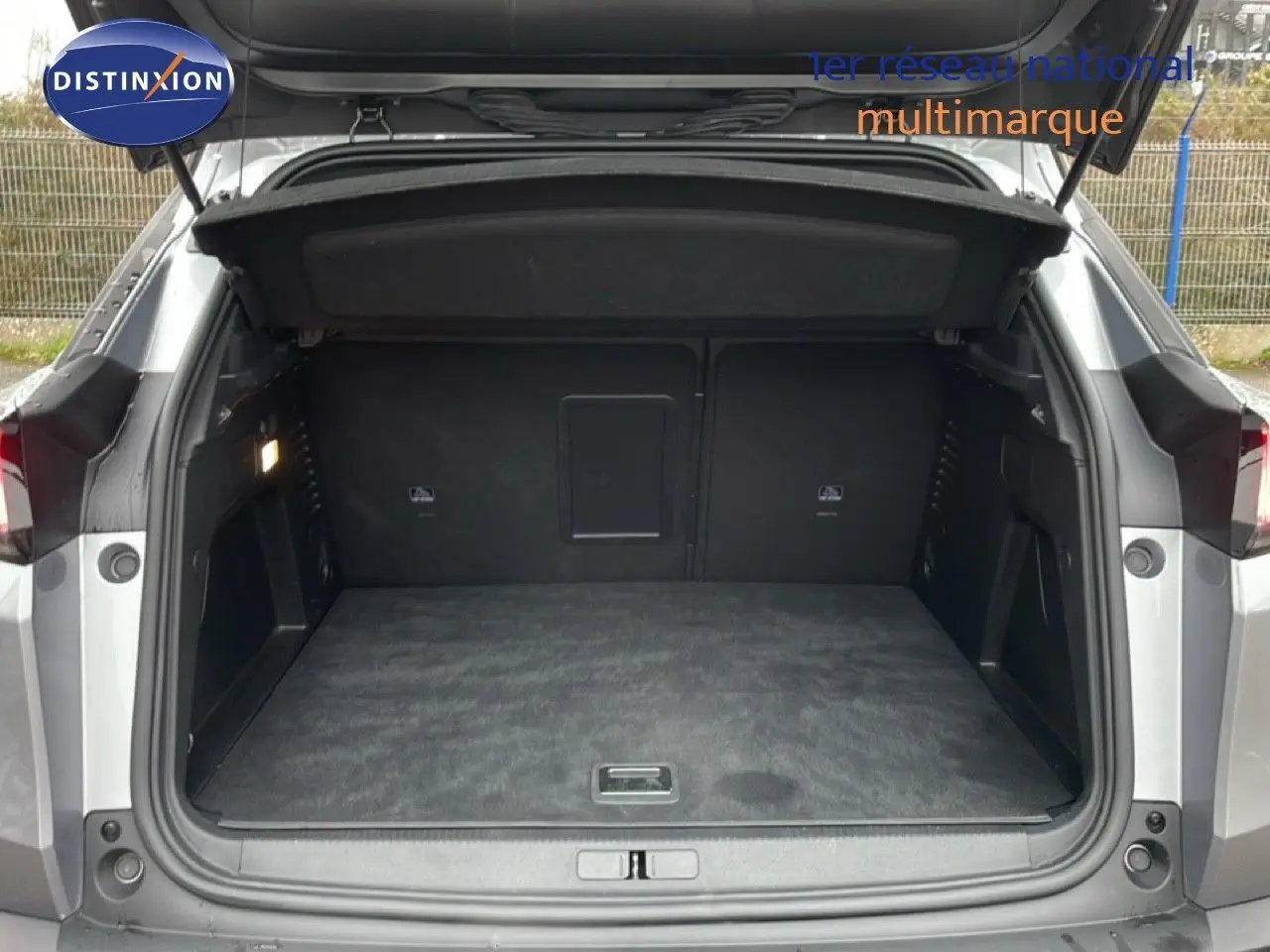 Coffre ouvert d’un Peugeot 3008 gris Artense métal, vue arrière montrant l’espace de chargement vide et l’intérieur noir.