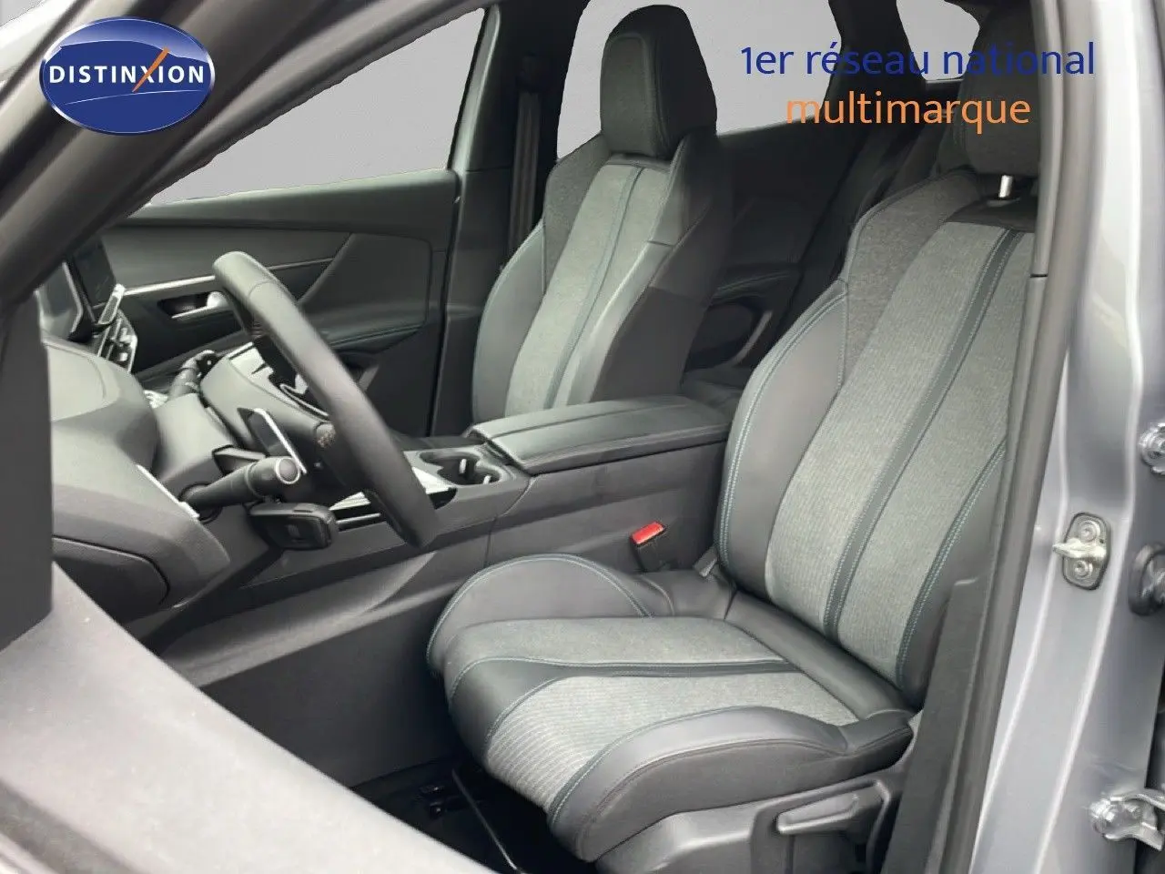Vue intérieure côté conducteur du Peugeot 3008 2024 gris Artense, sièges tissu et cuir avec console centrale visible.