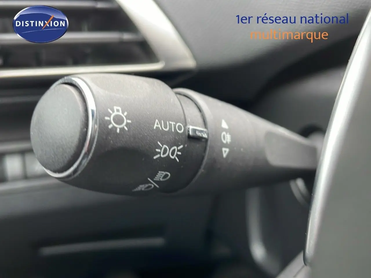 Gros plan sur la commande des feux du Peugeot 3008 gris Artense, intérieur noir, côté gauche du volant.
