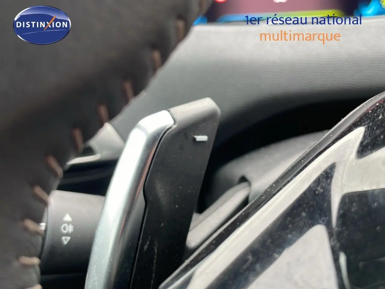 Gros plan sur la palette de changement de vitesse derrière le volant du Peugeot 3008 gris Artense 2024 hybride rechargeable.