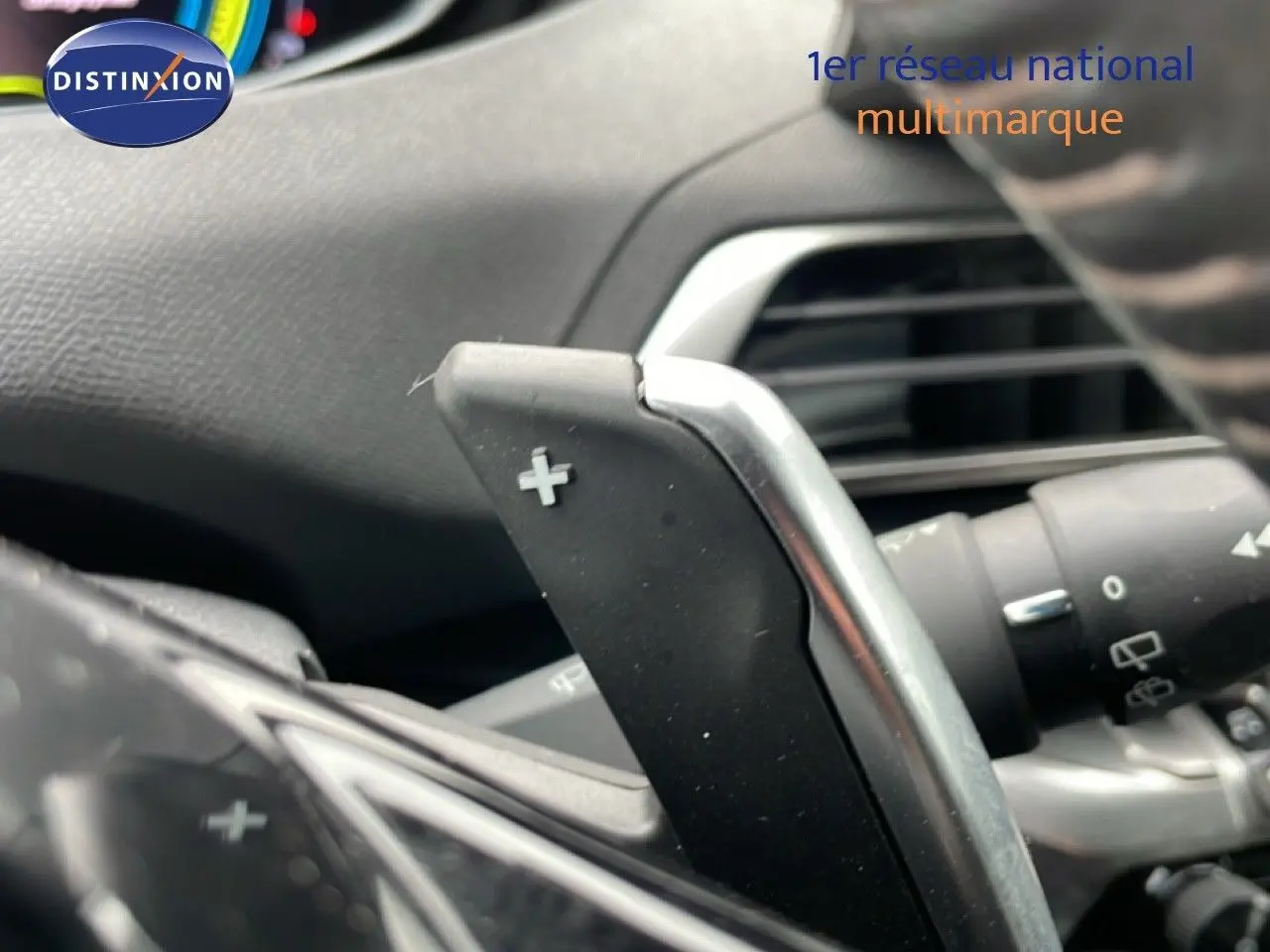 Gros plan sur la palette de changement de vitesse "+" du volant d'un Peugeot 3008 gris Artense hybride rechargeable 2024.