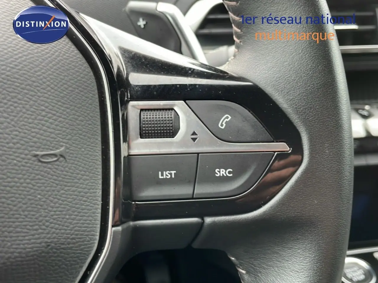 Gros plan sur les commandes gauche du volant en cuir noir du Peugeot 3008 gris Artense Metal 2024.