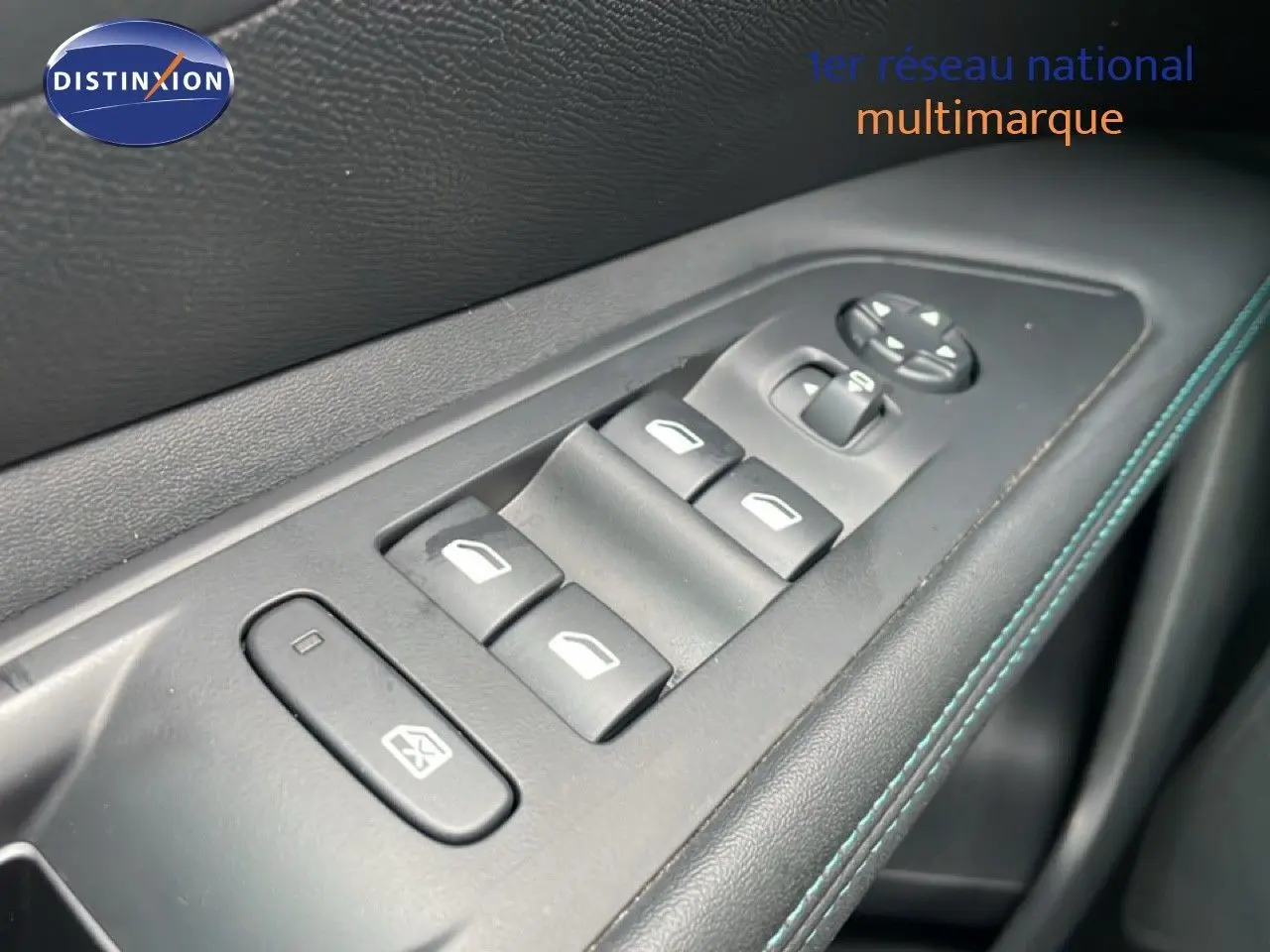 Gros plan sur les commandes des vitres électriques sur la porte côté gauche d’un Peugeot 3008 gris Artense Metal 2024.
