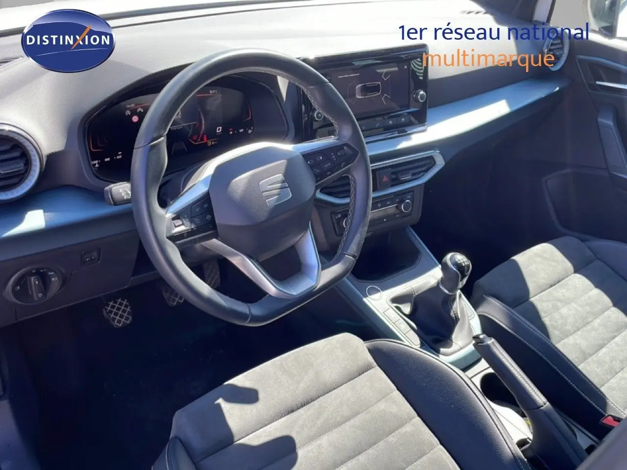 Vue intérieure côté conducteur du SEAT Arona 2025, volant cuir multifonction et tableau de bord numérique moderne.