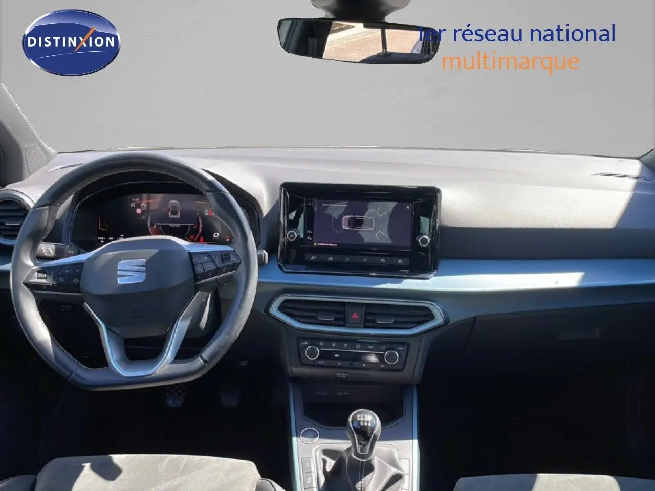 Vue intérieure frontale du tableau de bord de la SEAT Arona 2025 avec volant multifonction et écran tactile central.