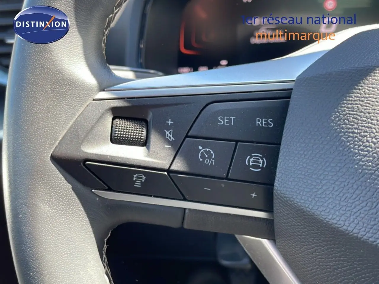 Gros plan sur les commandes de régulateur de vitesse au volant d’un SEAT Arona blanc alpin 2025, intérieur noir.