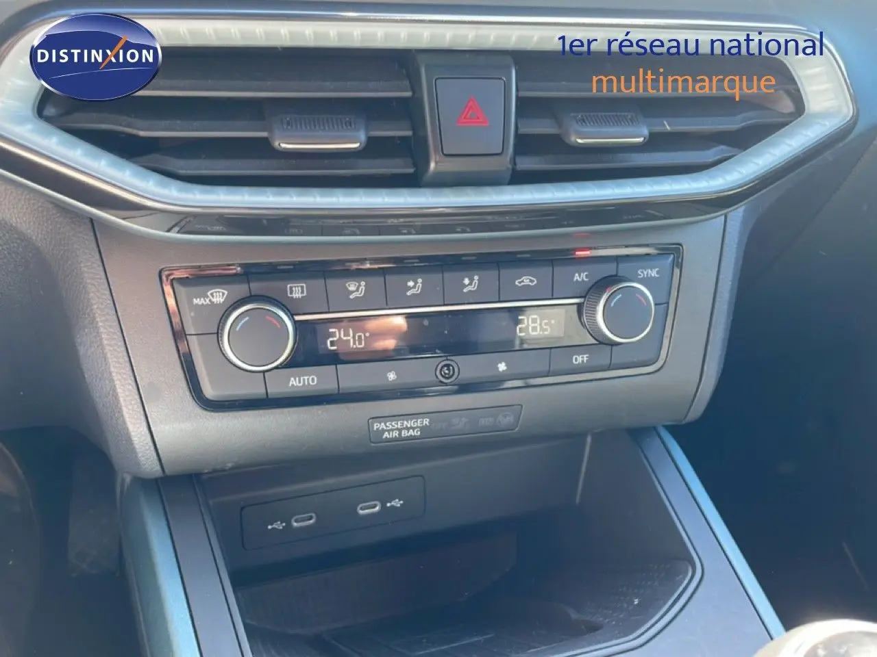 Gros plan sur la console centrale du SEAT Arona 2025, montrant la climatisation digitale et les ports USB.