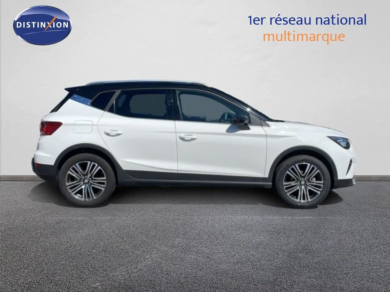 Vue latérale droite d'une SEAT Arona 2025 blanc alpin avec toit noir, jantes alliage et protections noires.