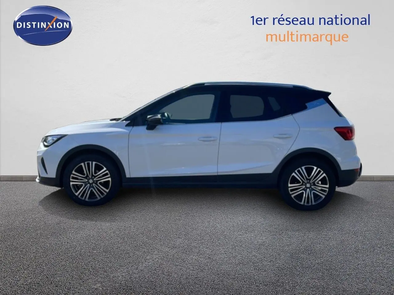 Vue latérale droite d'un SEAT Arona blanc alpin avec toit noir, soulignant ses jantes alliage et lignes modernes.