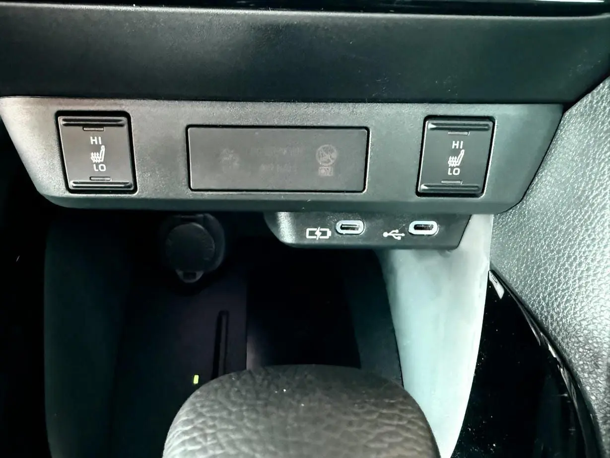 Détail de la console centrale de la Toyota Yaris Hybrid 2025 montrant les commandes de sièges chauffants et ports USB-C.