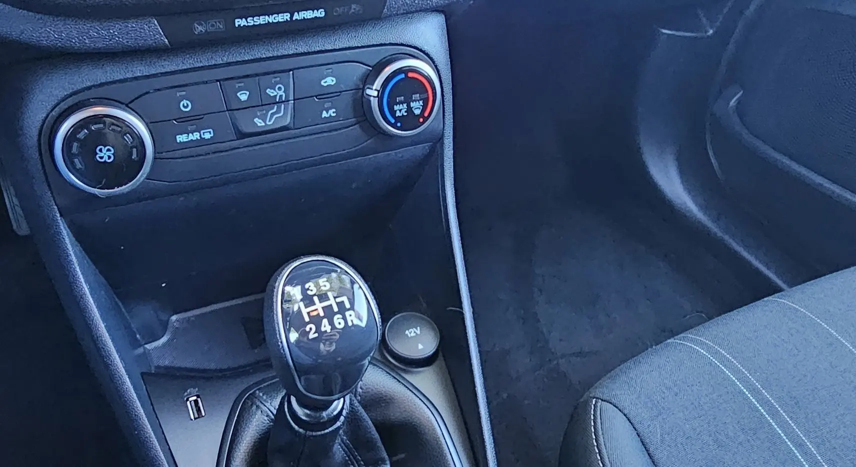 Gros plan sur la console centrale de la Ford Fiesta 2021 montrant le levier de vitesse manuel et les commandes de climatisation.