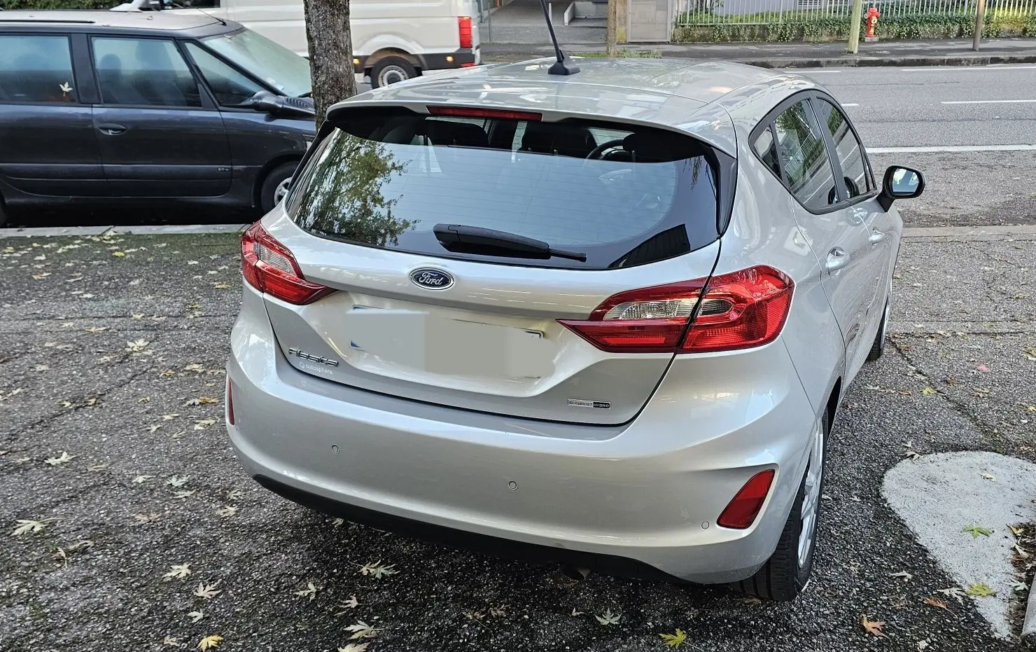 Vue 3/4 arrière droite d'une Ford Fiesta gris lunaire métal 2021 avec feux arrière et hayon visibles.