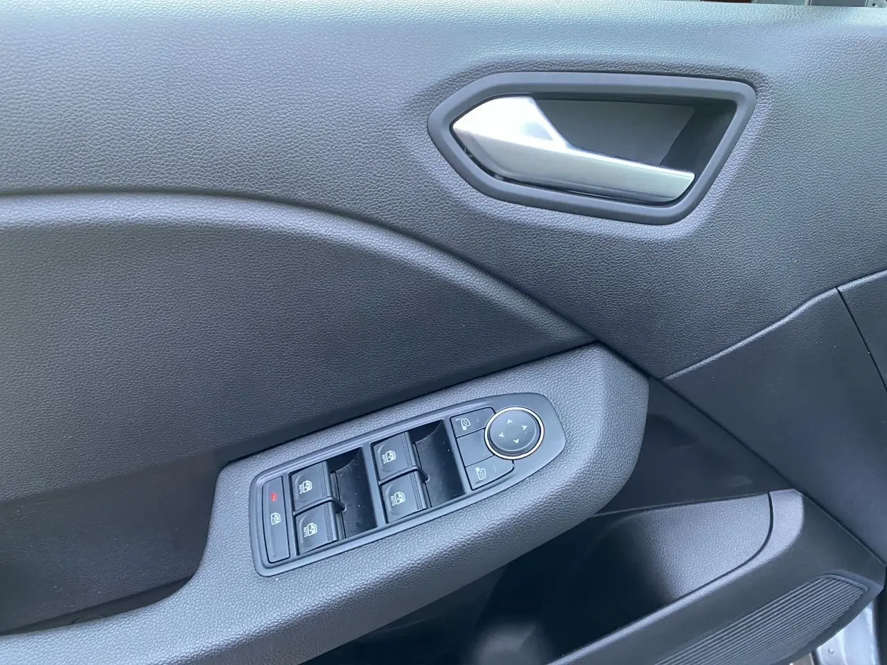 Détail de la porte avant gauche de la Renault Clio V gris schiste, avec commandes des vitres et rétroviseurs électriques.