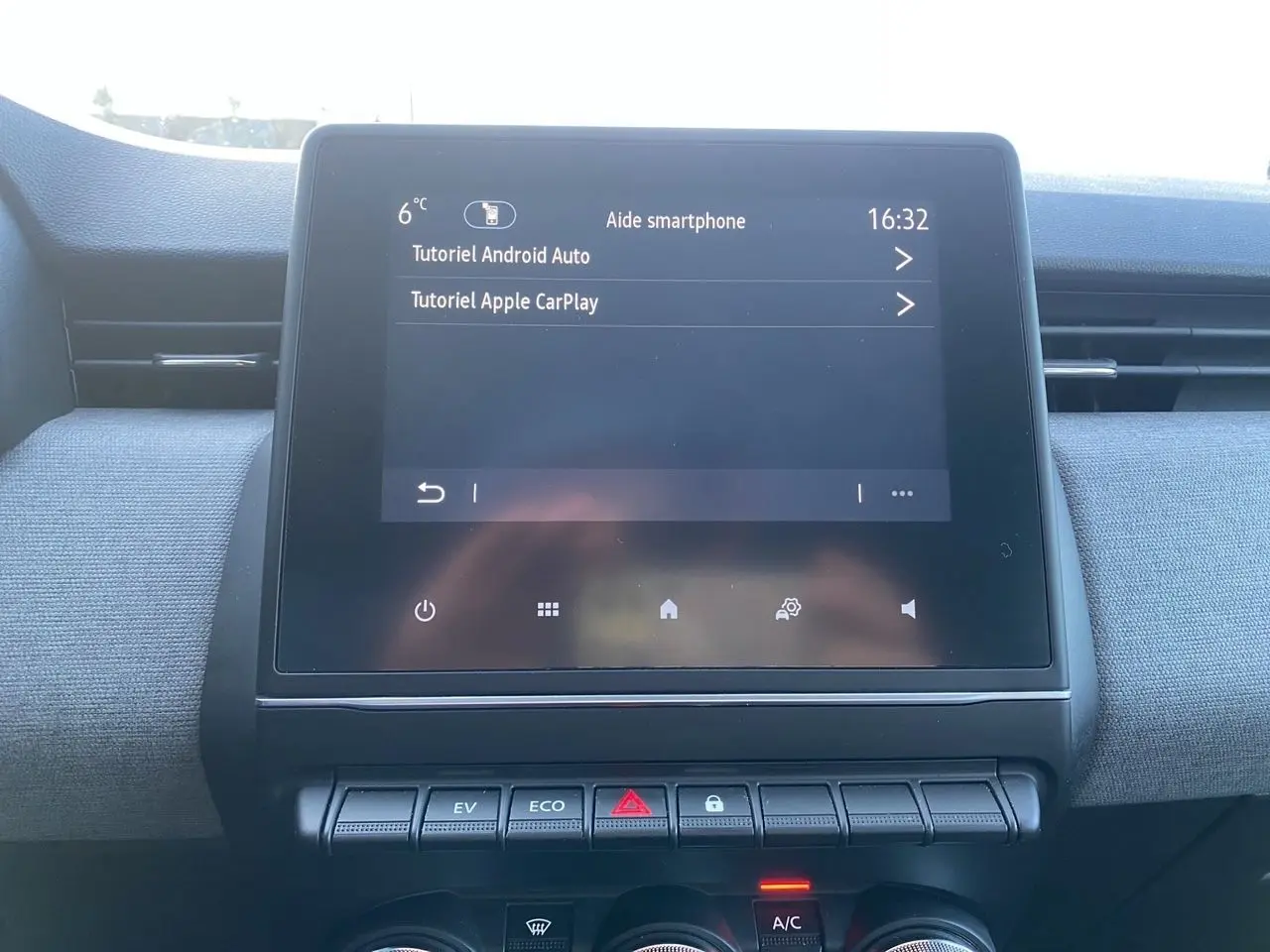 Écran tactile central de la Renault Clio V E-Tech gris schiste, affichant les tutoriels Android Auto et Apple CarPlay.