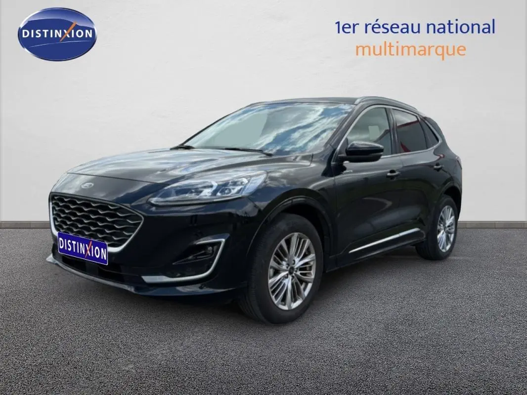 Ford Kuga noir vue 3/4 avant droit, avec jantes alliage 18 pouces et barres de toit visibles.
