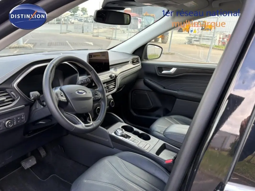 Intérieur avant droit du Ford Kuga noir 2024, avec tableau de bord moderne, écran tactile et sièges sport en cuir.