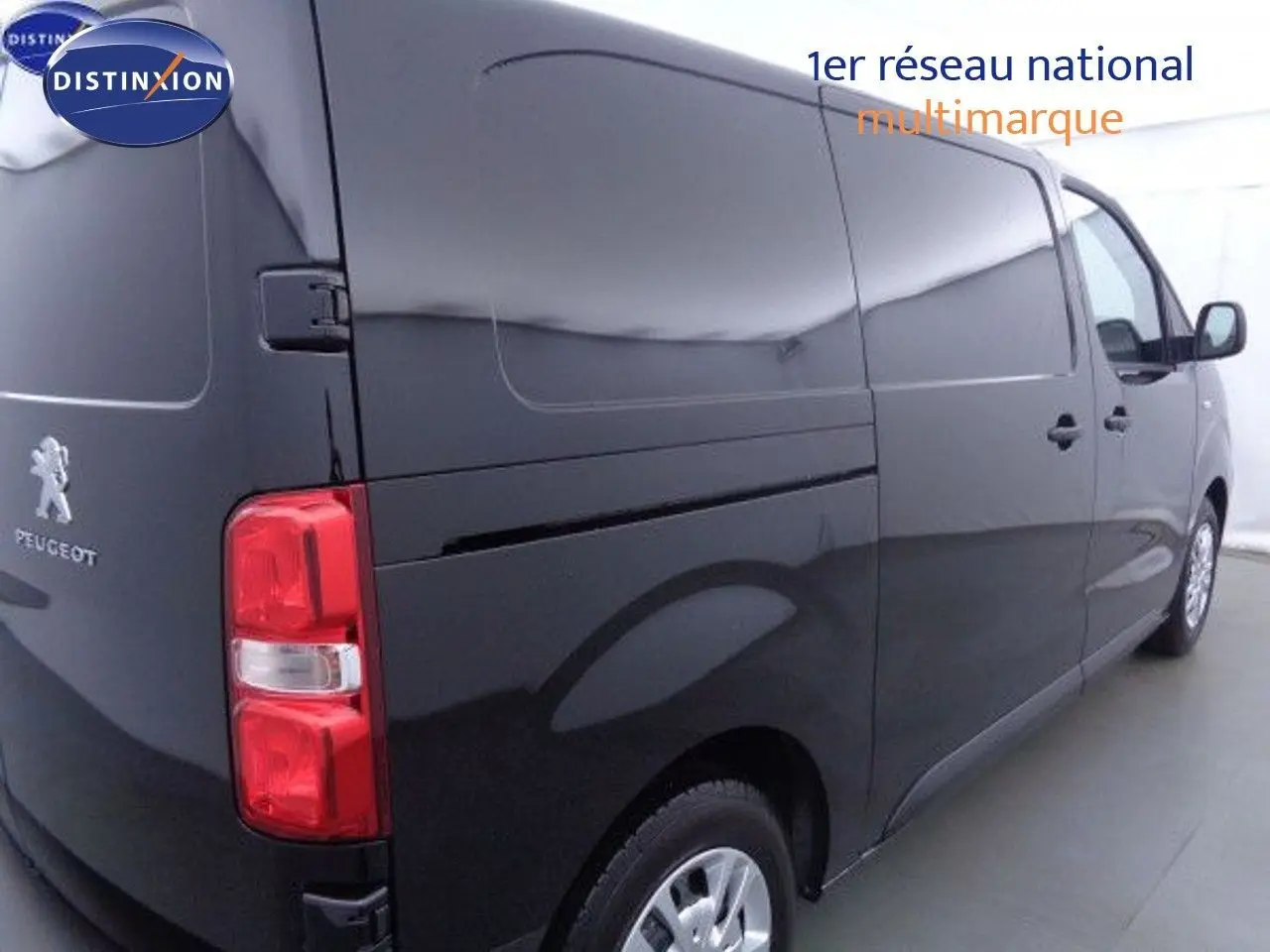 Vue 3/4 arrière droite d'un Peugeot Expert Fourgon noir métal, mettant en valeur la porte latérale et les feux arrière rouges.