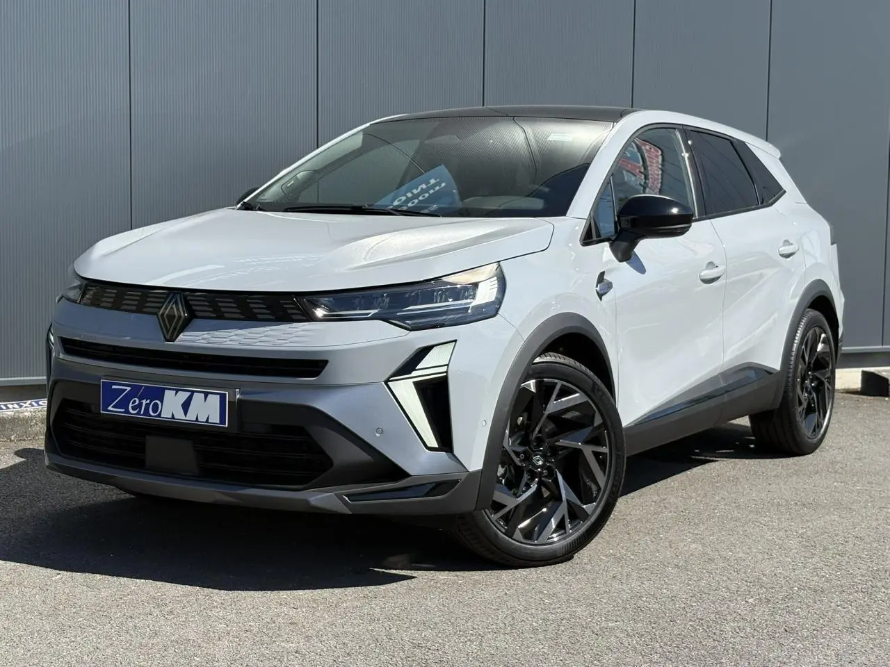 Vue 3/4 avant droit du Renault SYMBIOZ gris Rafale avec toit panoramique Solarbay et jantes noires distinctives.