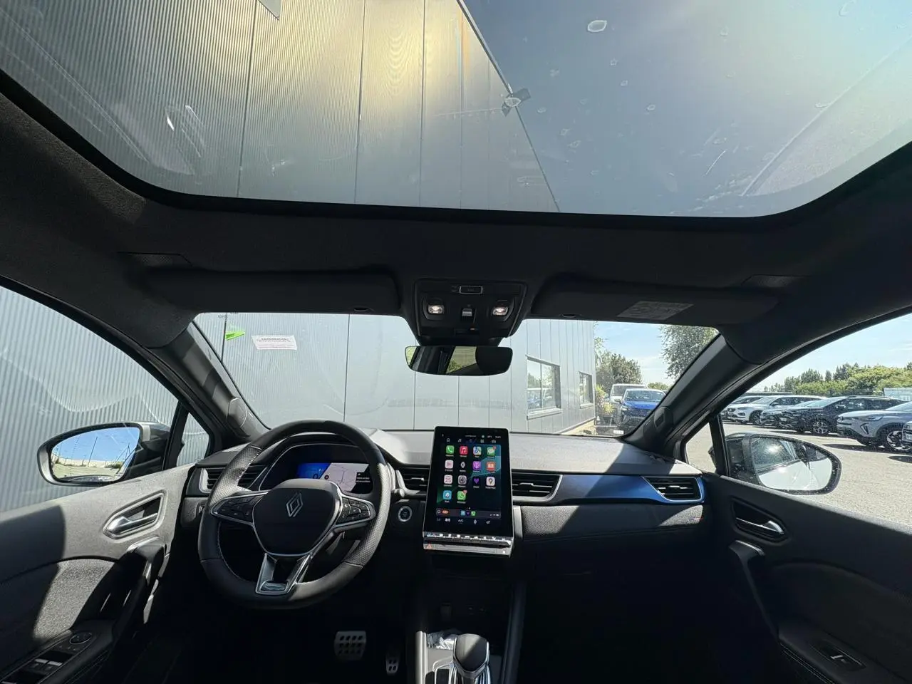 Vue intérieure avant du Renault SYMBIOZ gris Rafale avec toit panoramique Solarbay et écran tactile central.