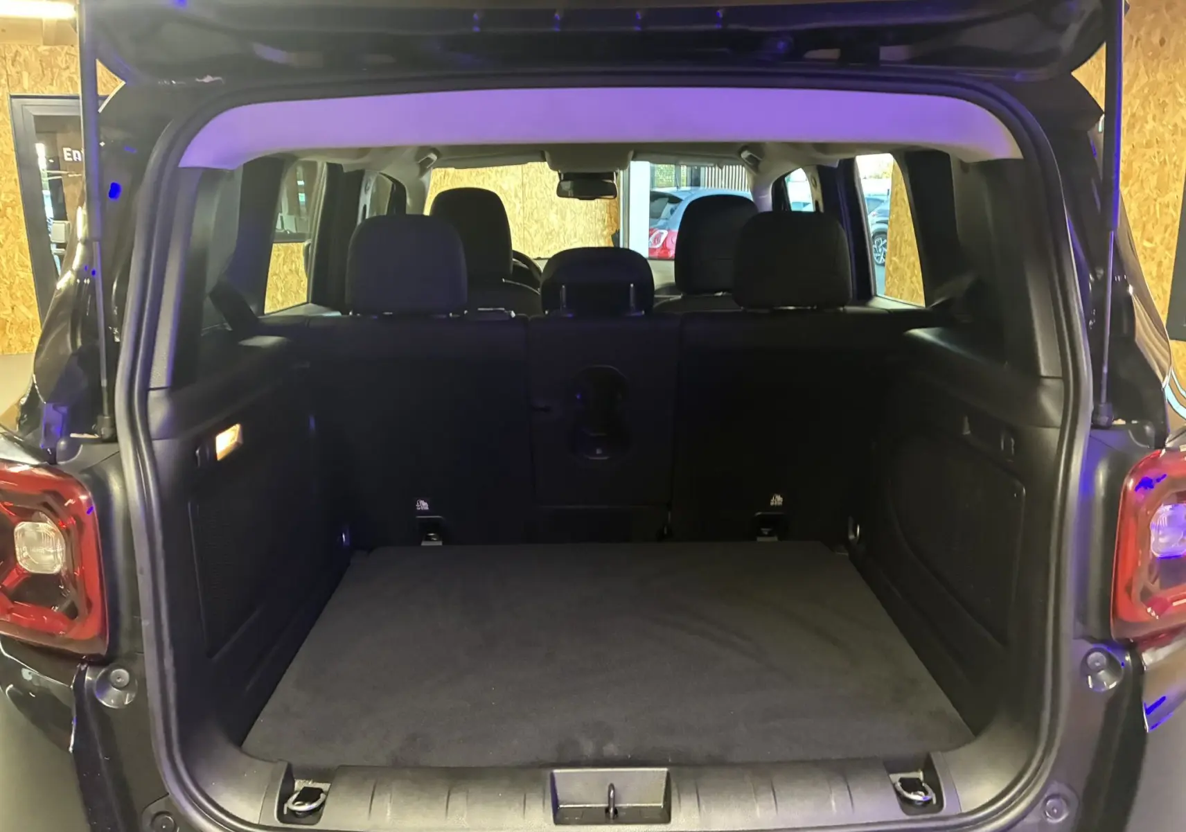 Coffre ouvert d'un Jeep Renegade noir 2019, vue arrière montrant l'espace de chargement et les sièges arrière.