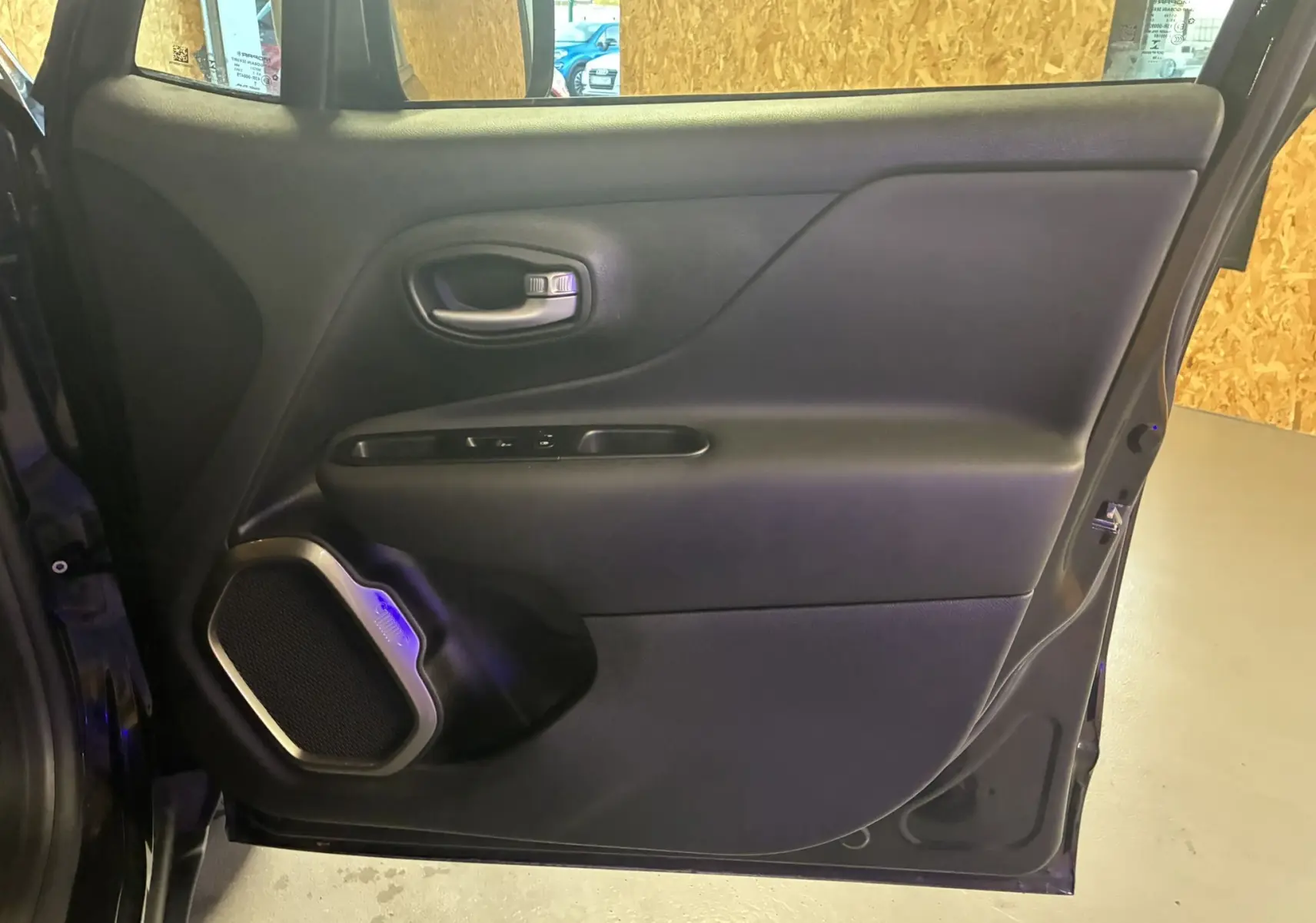 Porte intérieure arrière gauche noire du Jeep Renegade 2019 avec haut-parleur et poignée intégrée.