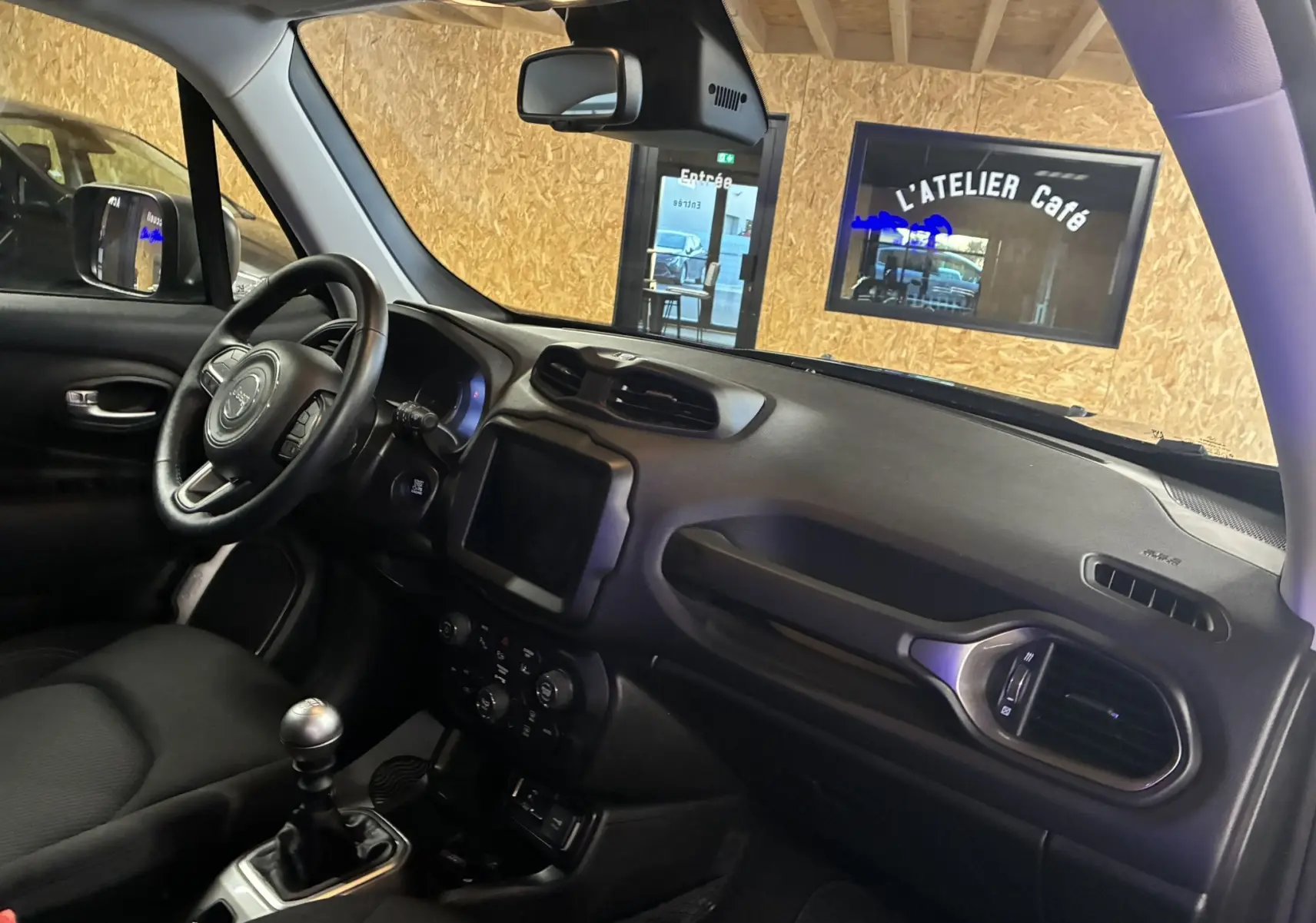 Intérieur noir du Jeep Renegade 2019, vue côté conducteur sur tableau de bord et volant avec boîte manuelle.