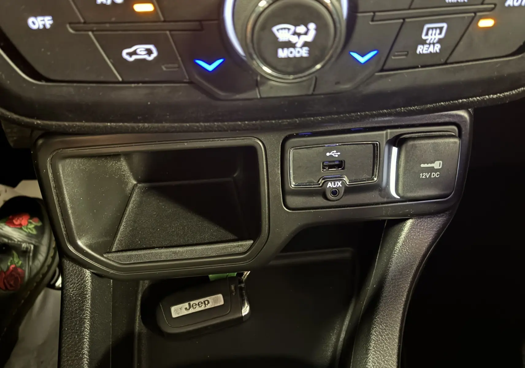 Gros plan sur la console centrale noire du Jeep Renegade 2019, montrant prises USB, AUX, prise 12V et clé Jeep.