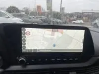 Écran tactile central de la Hyundai i20 2025 affichant la navigation, intérieur noir avec commandes modernes visibles.