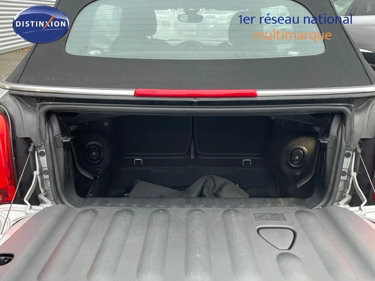 Coffre ouvert d'une MINI Cabriolet F57 Melting Silver, vue arrière mettant en valeur l'espace de rangement noir.