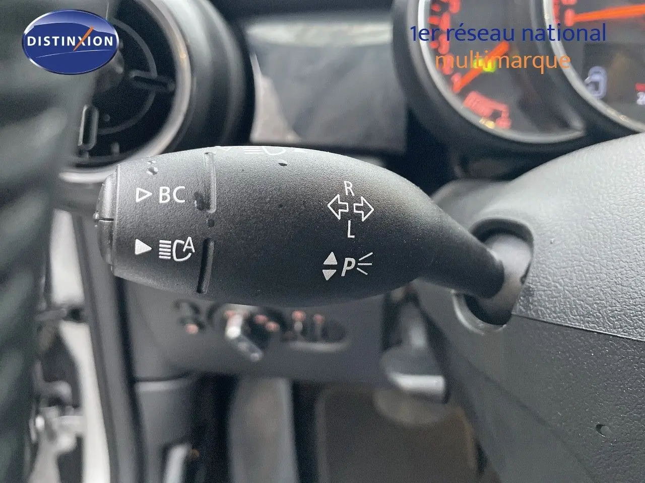 Le levier de clignotant noir du tableau de bord d'une MINI Cabriolet 2023, avec compteurs en arrière-plan.