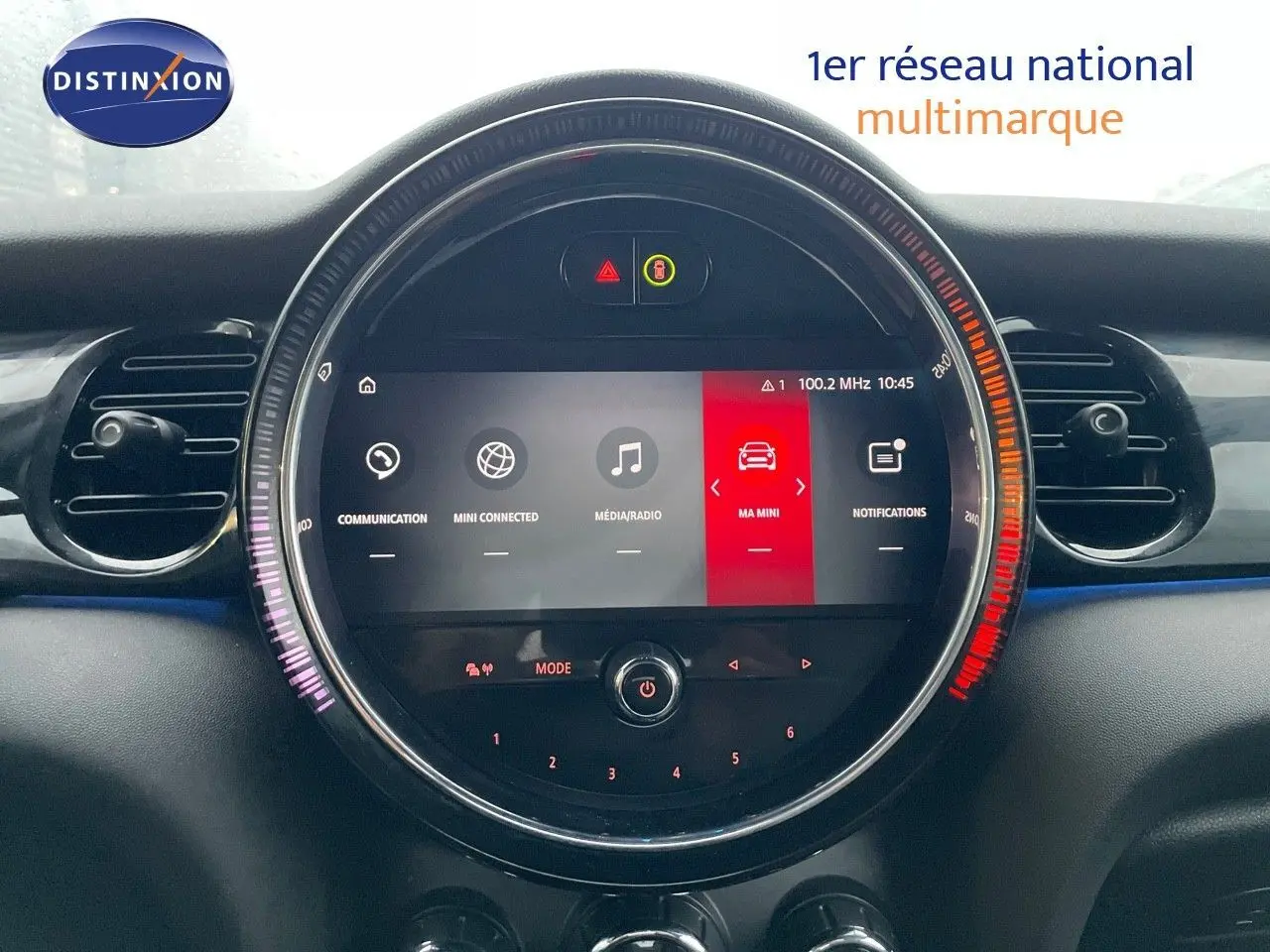 Vue rapprochée du tableau de bord de la MINI Cabriolet F57 2023, écran central rond avec interface multimédia colorée.