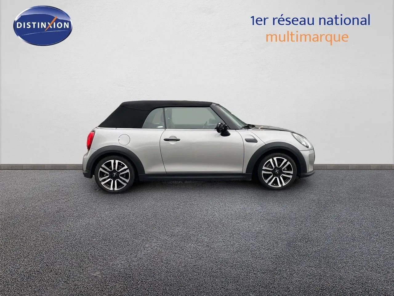 Profil droit d'une MINI Cabriolet 2023 couleur argent métallisé avec toit noir fermé sur fond neutre.
