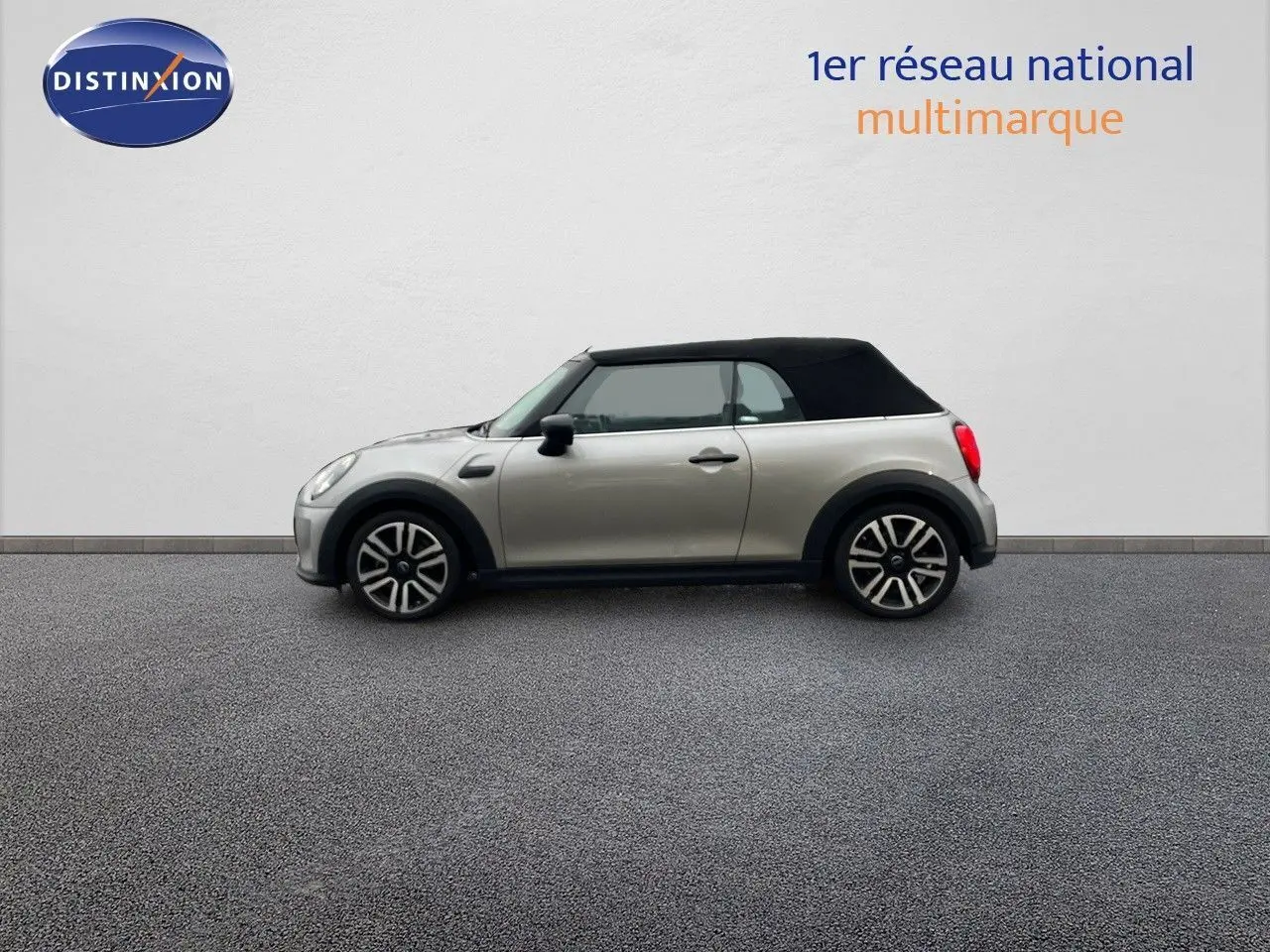 Profil gauche d'une MINI Cabriolet 2023 couleur Melting Silver avec capote noire fermée sur fond neutre.