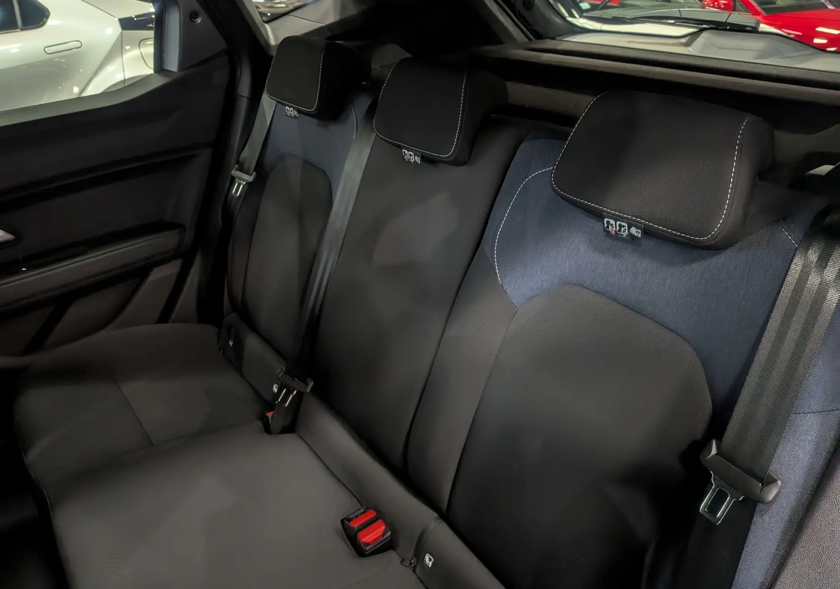 Vue intérieure sur la banquette arrière en tissu noir et bleu du Dacia Duster Mild Hybrid 2025.