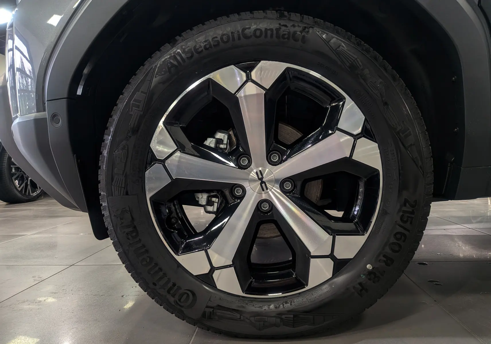 Gros plan sur la jante bi-ton noire et argent du Dacia Duster gris schiste, mettant en valeur le design moderne du pneu Continental.