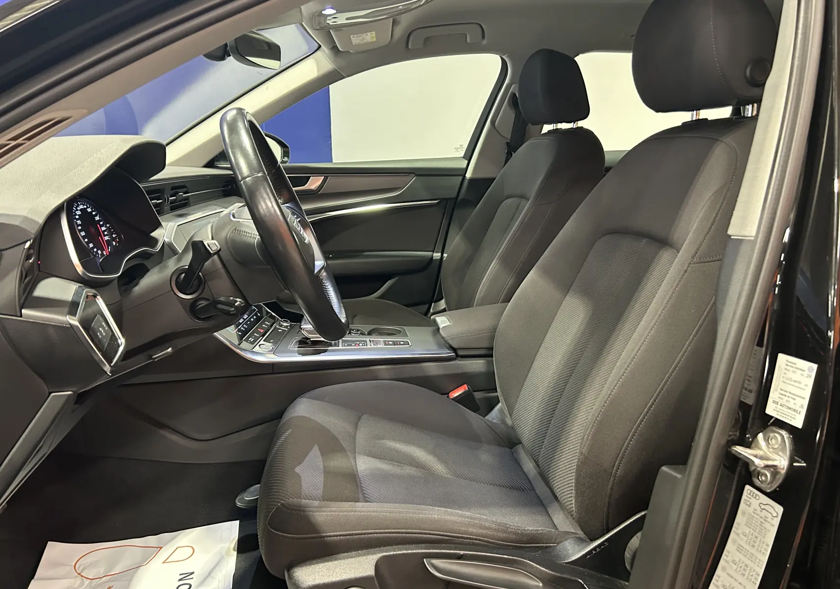 Intérieur noir de l'Audi A6 Avant 40 TDI 2019, vue côté conducteur avec sièges tissu et tableau de bord moderne.